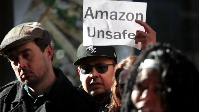 Amazon workers with an Amazon Unsafe sign