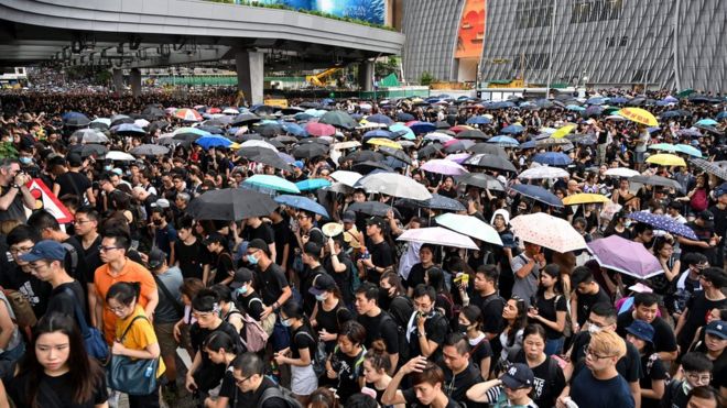 Протестующие несут зонтики во время марша к железнодорожной станции Западный Коулун против предложенного законопроекта об экстрадиции и перед столкновением с полицией в районе Монг Кок в Коулуне в Гонконге 7 июля 2019 г.