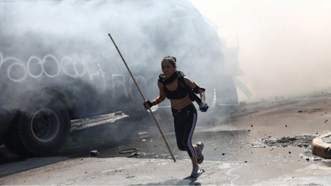 Una manifestante huye de los gases lacrimógenos en las protestas en Chile