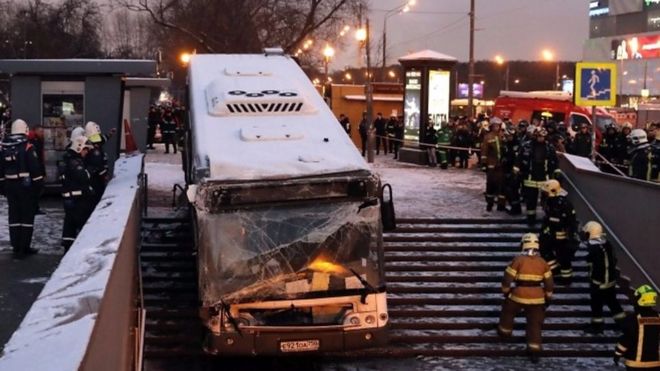 Firemen gather around a crashed bus by the entrance of a pedestrian underpass in Moscow