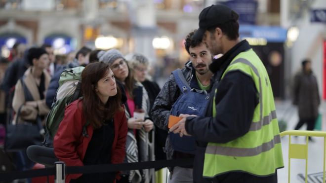 Пассажиры в лондонском штате Виктория беседуют с южным представителем в очереди за очередным экспрессом до аэропорта Гатвик