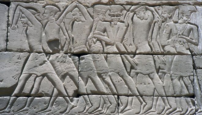 Морские Народы: Скованные и связанные Пелесетом или Филистимлянами заключенные, захваченные египтянами в морском сражении. На стенах храма Мединет Абу Рамсеса III