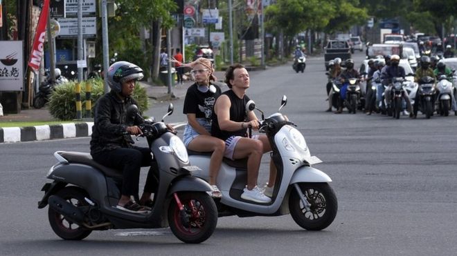 Sejumlah turis asing mengendarai sepeda motor tanpa mengenakan helm di Jalan Sunset Road, Kuta, Badung, Bali, Selasa (28/2/2023).