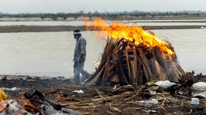 갠지스강 둑에서 코로나19 사망자의 시신이 장작불로 화장되고 있다