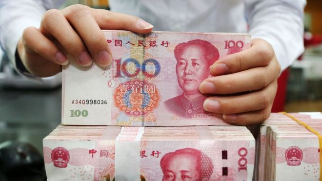 23 июля 2018 года служащий считает банкноты в 100 юаней в банке в Наньтуне, в восточной китайской провинции Цзянсу.