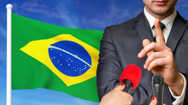 candidato em frente à bandeira brasileira