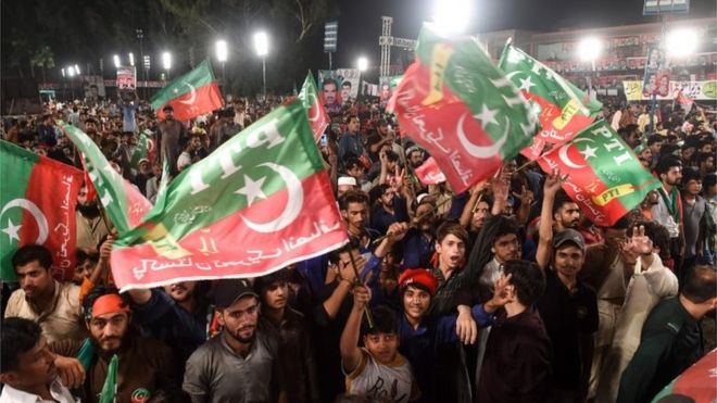 Сторонники пакистанского крикета, ставшего политиком, и глава пакистанского Техрик-и-Инсафа (PTI) Имран Хан (незаметно) собрались на митинг своей политической кампании на предстоящих всеобщих выборах в Лахоре 18 июля 2018 года