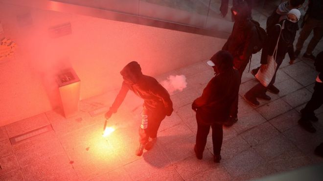 Протестующий держит вспышку в Нант, Франция