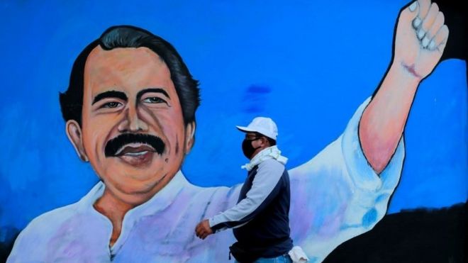 A man walks by a mural depicting Nicaraguan President Daniel Ortega, in Managua