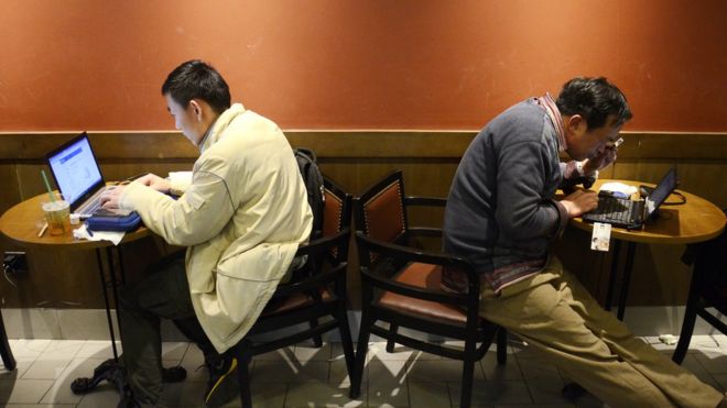 Мужчины пользуются интернетом в кафе в китайской столице Пекине в 2012 году.
