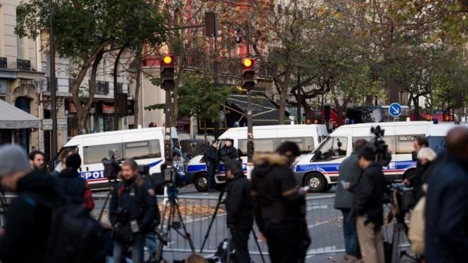 Журналист стоит перед театром Батаклана в Париже