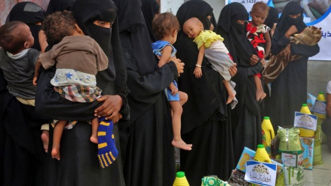 Yemeni women and children wait during food distribution in the province of Hodeida, Yemen, on 30 May 2018