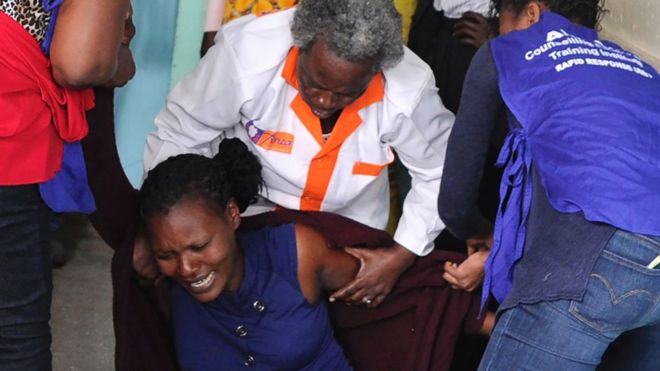 Родственник утешается медицинским персоналом скорой помощи в школе для девочек в Найроби, после того, как смертельная вспышка на рассвете потопила одно из пансионов в школе, что привело к нескольким смертям, 2 сентября 2017 года