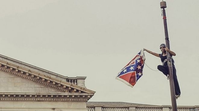 Бри Ньюсом снимает флаг Конфедерации с шеста в здании Государственного дома в Колумбии, штат Южная Каролина, 27 июня 2015 года.