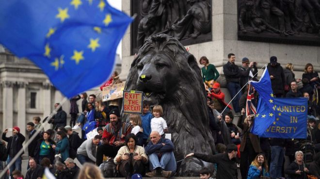 People gather next to a stone lion at Trafalgar Square during the "Put it to the People" march in London, Britain, 23 March 2019