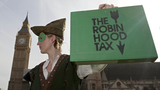 Участник так называемого налога Робин Гуда, одетый как Робин Гуд, стоит перед парламентом, 2010