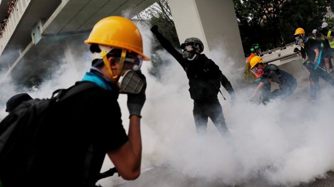 Демонстранты реагируют на слезоточивый газ во время акции протеста против атак Yuen Long в Yuen Long, New Territories, Гонконг, Китай 27 июля 2019 г.