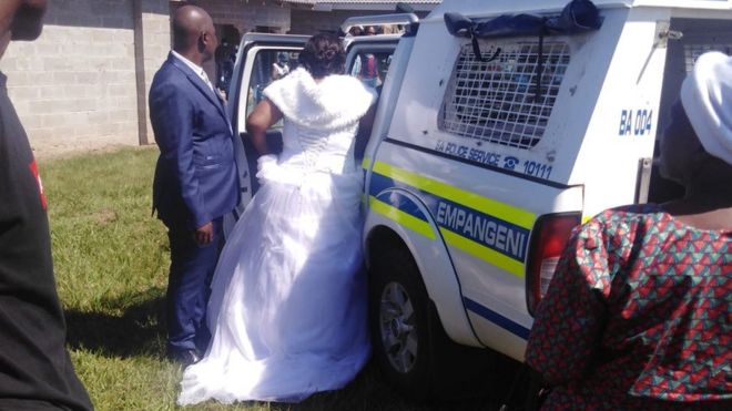 The bride getting into a police vehicle