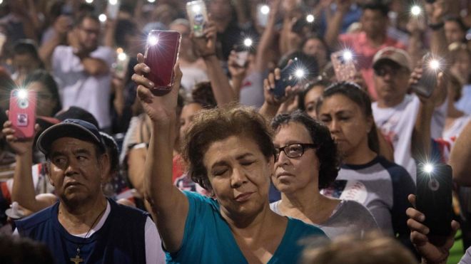 Люди держат свои телефоны во время молитвы и бдения свечей, организованных городом, после того, как 4 августа 2019 года в торговом центре Cielo Vista Mall Wal-Mart в Эль-Пасо, штат Техас, погибло 20 человек.