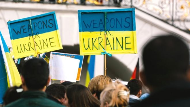 Manifestantes en Bonn sostienen carteles que leen: "Armas para Ucrania", 10 de abril, 2022