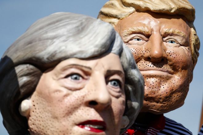 Активисты антикапитализма в масках премьер-министра Великобритании Терезы Мэй (слева) и президента США Дональда Трампа протестуют в Гамбурге, 6 июля