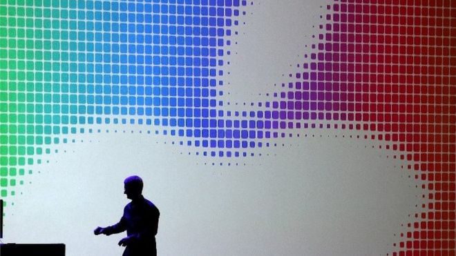 Тим Кук на сцене перед логотипом Apple