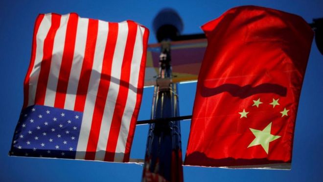 Flags of the United States and China fly from a lamppost