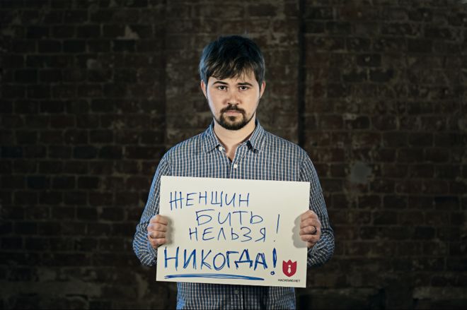 Музыкант Вася Обломов держит открытку с надписью «Женщин бить нельзя!