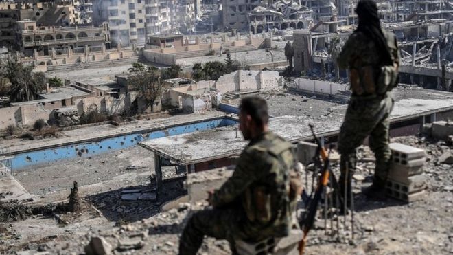 시리아민주군(SDF)가 지붕 위에서 IS로부터 탈환한 락까를 바라보고 있다.