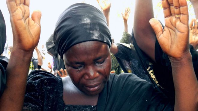 Бинту Битрус, мать Годии, одна из пропавших учениц Чибок, плачет, поднимая руки вместе с другими родителями, чтобы помолиться об освобождении их дочерей, похищенных джихадистами Боко харам, во время богослужения в ознаменование четвертого годовщины похищение в городе Чибок, штат Борно, 14 апреля 2018 года