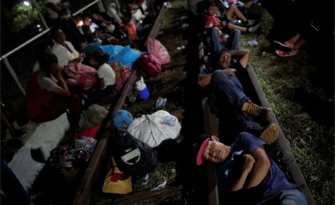 Гондурасские мигранты отдыхают на мосту, который связывает Мексику и Гватемалу, в Сьюдад-Идальго, Мексика