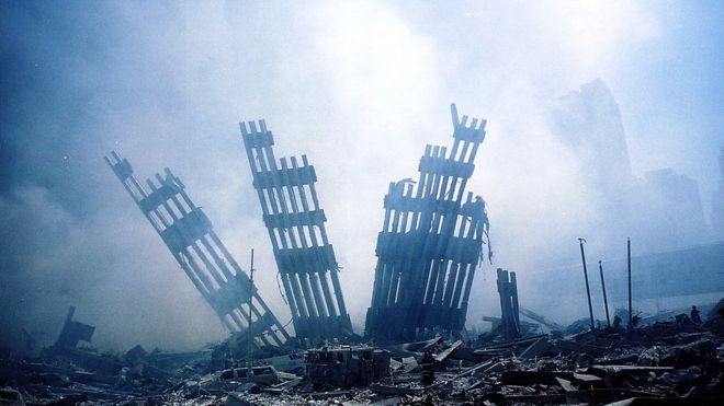 Обломки Всемирного торгового центра тлеют после теракта 11 сентября 2001 года в Нью-Йорке
