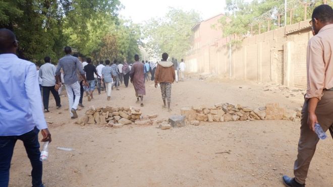 Люди идут по дороге к сидячей забастовке военного штаба в Хартуме, Судан, понедельник, 8 апреля 2019 года
