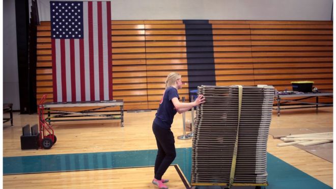 A volunteer stacks up chairs at a campaign site in Ohio, which is delaying its 17 March primary contest