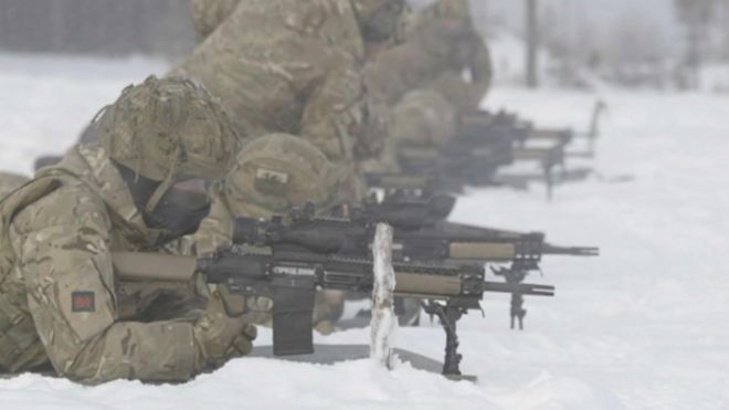 Солдаты лежат, стреляя из винтовок в снегу