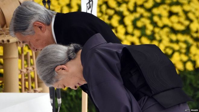 Император Акихито (слева) и императрица Мичико (справа) склоняются перед алтарем во время ежегодной поминальной службы для жертв войны в Токио 15 августа 2015 года