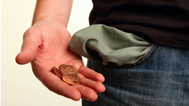 Крупным планом мужская рука с вывернутым карманом и монетами