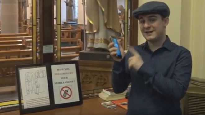 Мужчина в кепке держит телефон на веранде церкви