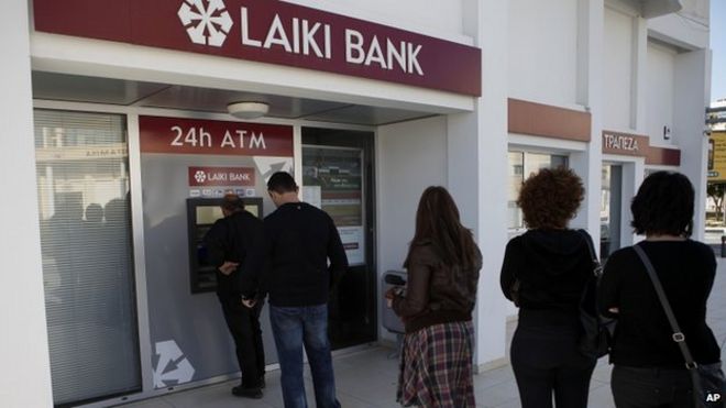 Люди стоят в очереди, чтобы воспользоваться банкоматом возле отделения Laiki Bank в Ларнаке, Кипр, в марте 2013 года