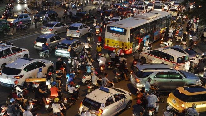 Мотоциклисты среди движения в час пик на перекрестке в Ханое