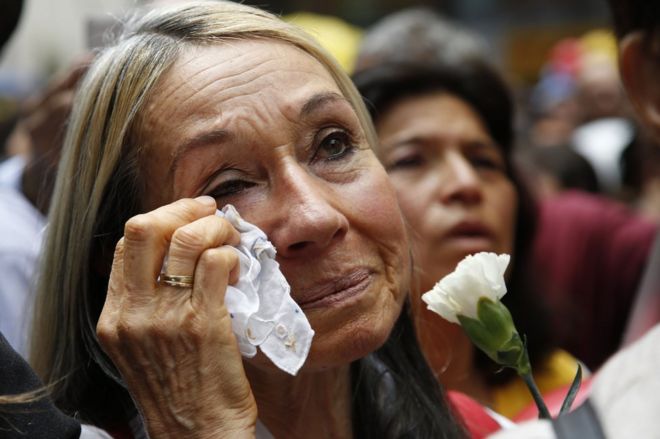 Женщина плачет, наблюдая в прямом эфире из Гаваны церемонию заключения соглашения между президентом Колумбии и главой повстанцев Фарка о соглашении о прекращении огня и разоружении повстанцев, в Боготе, Колумбия, 23 июня
