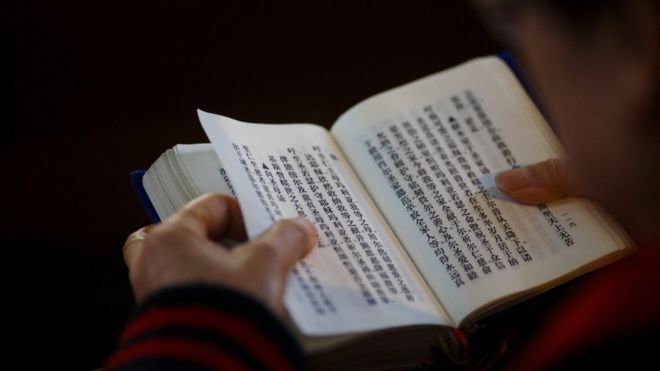 A believer reads the bible during mass at St. Joseph"s Church, a government-sanctioned Catholic church, in Beijing, China, October 1, 2018. REUTERS/Thomas Peter