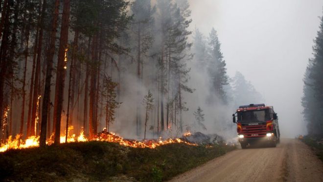 A fire vehicle is seen as fire burns in Karbole, Sweden, on July 15, 2018.