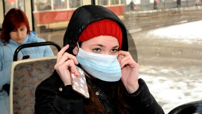 Дівчина вдягає маску