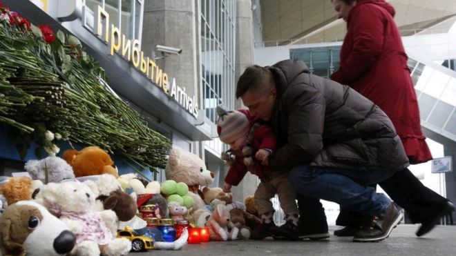 Люди возлагают цветы и игрушки у входа в аэропорт Пулково под Санкт-Петербургом, в день национального траура по жертвам авиакатастрофы, в воскресенье, 1 ноября 2015 года.