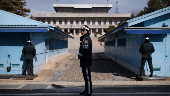 Южнокорейский солдат стоит перед военной демаркационной линией в деревне Панмунжом, в демилитаризованной зоне, разделяющей две Кореи, в 2018 году