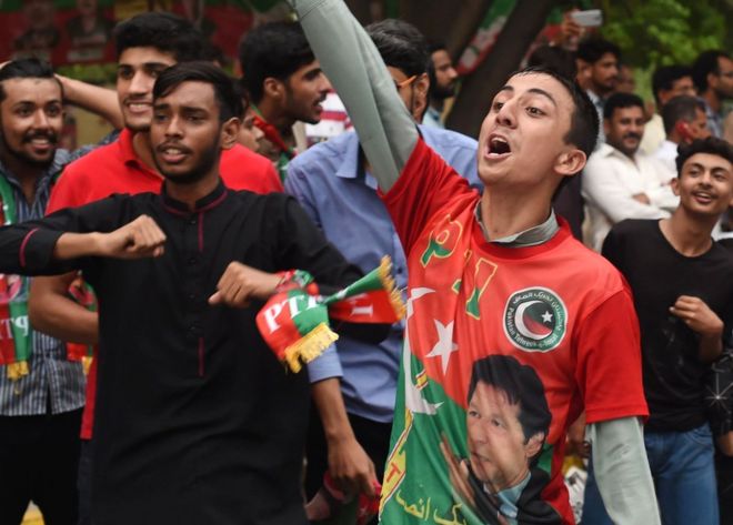 Сторонники пакистанской звезды крикета, ставшего политиком и главой пакистанского «Техрик-и-Инсаф» (PTI) Имрана Хана, приветствуют их выход на улицы, чтобы отпраздновать закрытие избирательных участков во время всеобщих выборов в Пакистане, Лахор, 25 июля 2018 года