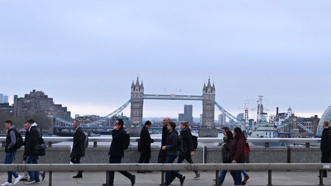 Пассажиры на мосту через Темзу в Лондоне