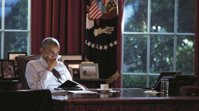 Obama sits at his desk