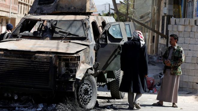 Мужчины осматривают бронированный автомобиль, уничтоженный в ходе столкновений между повстанцами хути и сторонниками Али Абдаллы Салеха в Сане, Йемен (5 декабря 2017 года)